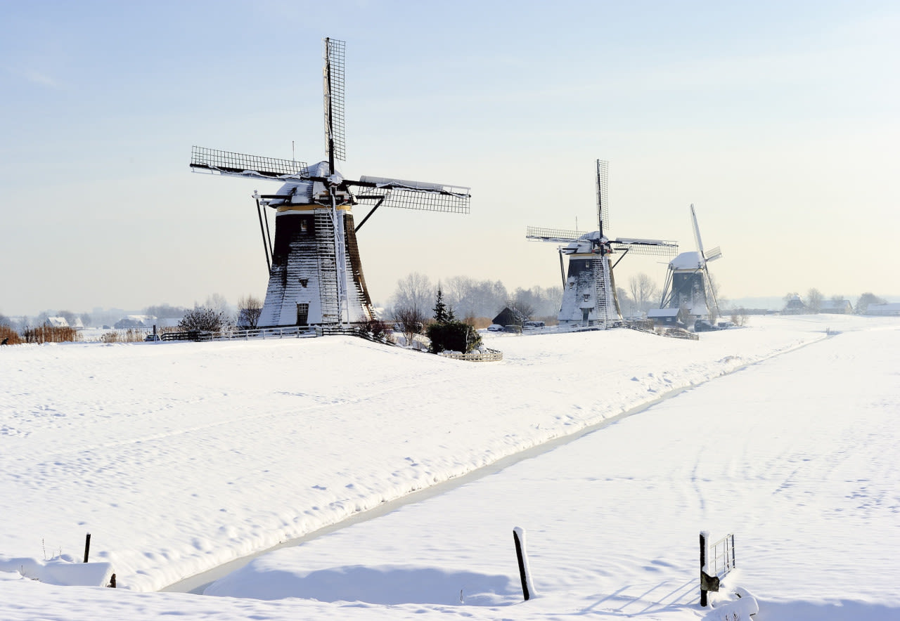 De belichting in deze foto is precies goed waardoor de sneeuw een mooie kleur krijgt. Het rijtje molens zorgt voor extra diepte. Foto: ANP / Lex van Lieshout.