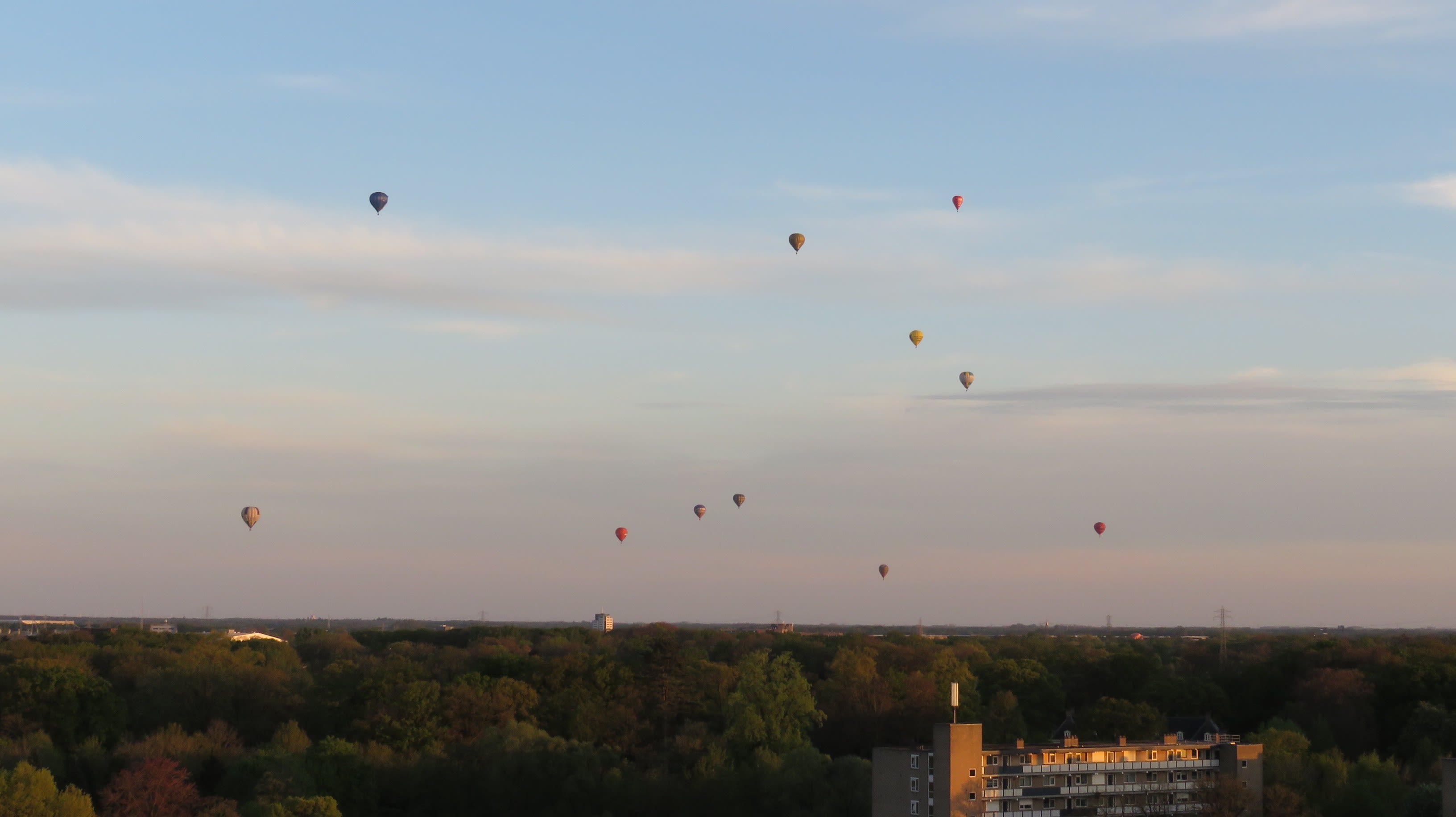 Een verzameling luchtballonnen boven Almelo tijdens zonsondergang. Foto: Frits Westra.