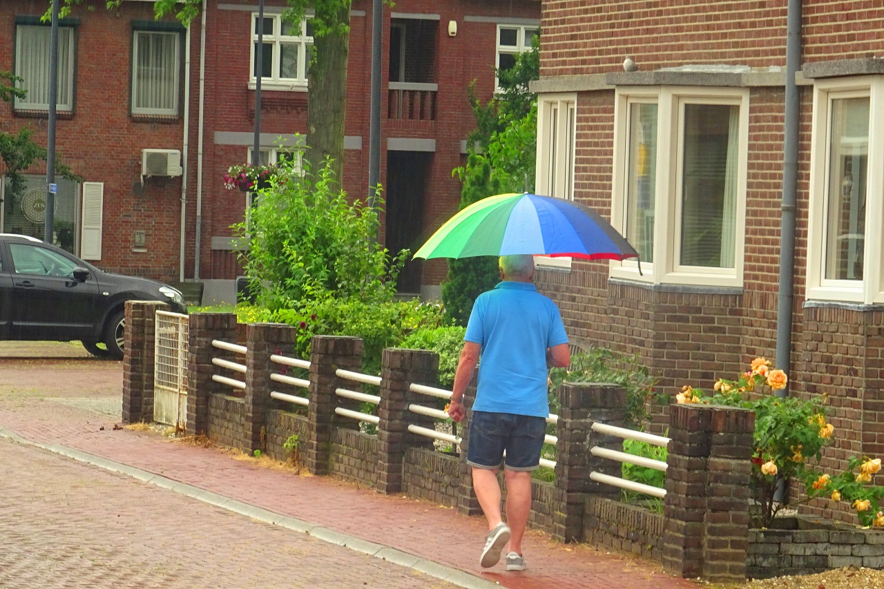 Man met paraplu in recordwarme junimaand 2021