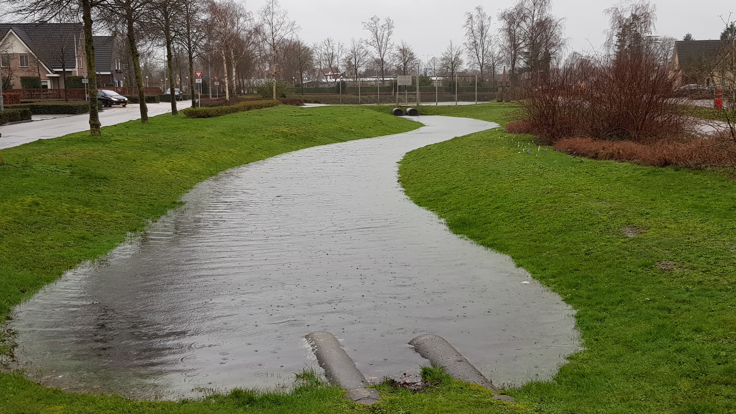 Wadi in een woonwijk. Een lange kuil in het gras vangt overtollig water op.
Foto: Theo van Dalen
