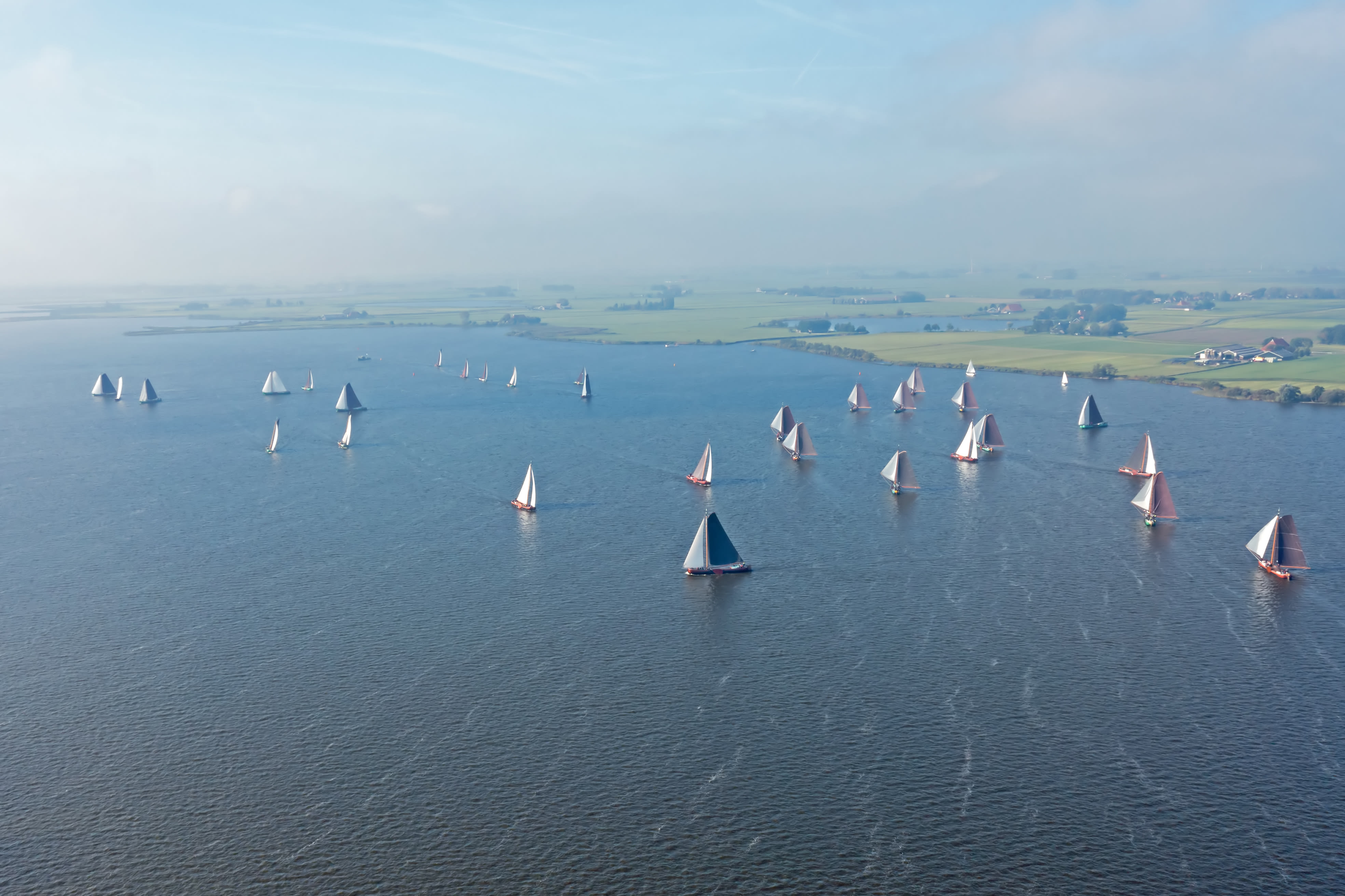 Luchtfoto van het skûtsjesilen op het meer de Fluessen in Friesland. Foto: Adobe Stock / Nataraj
