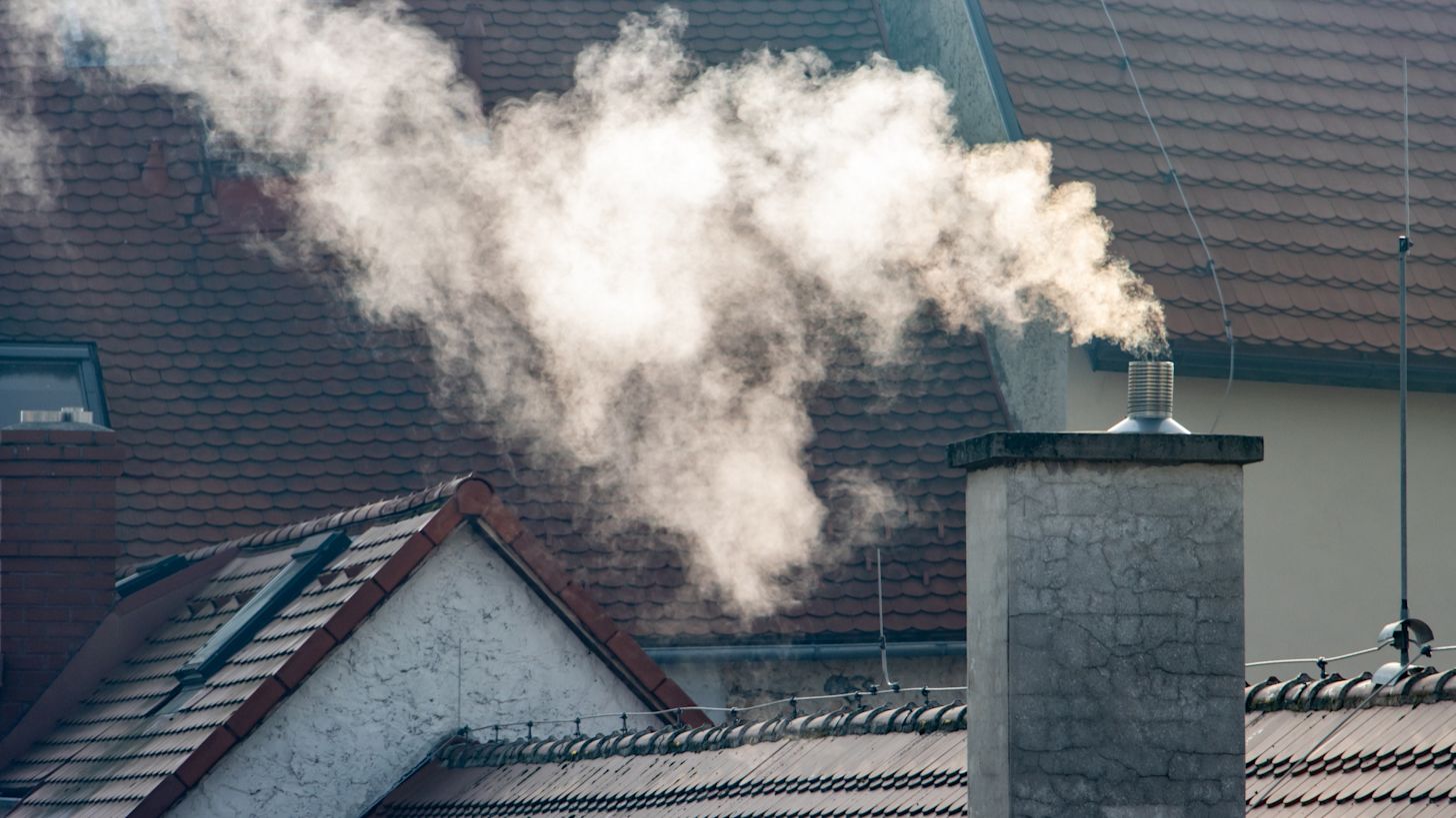 Rook van houtkachels kan blijven hangen. Foto: AdobeStock / milkovasa