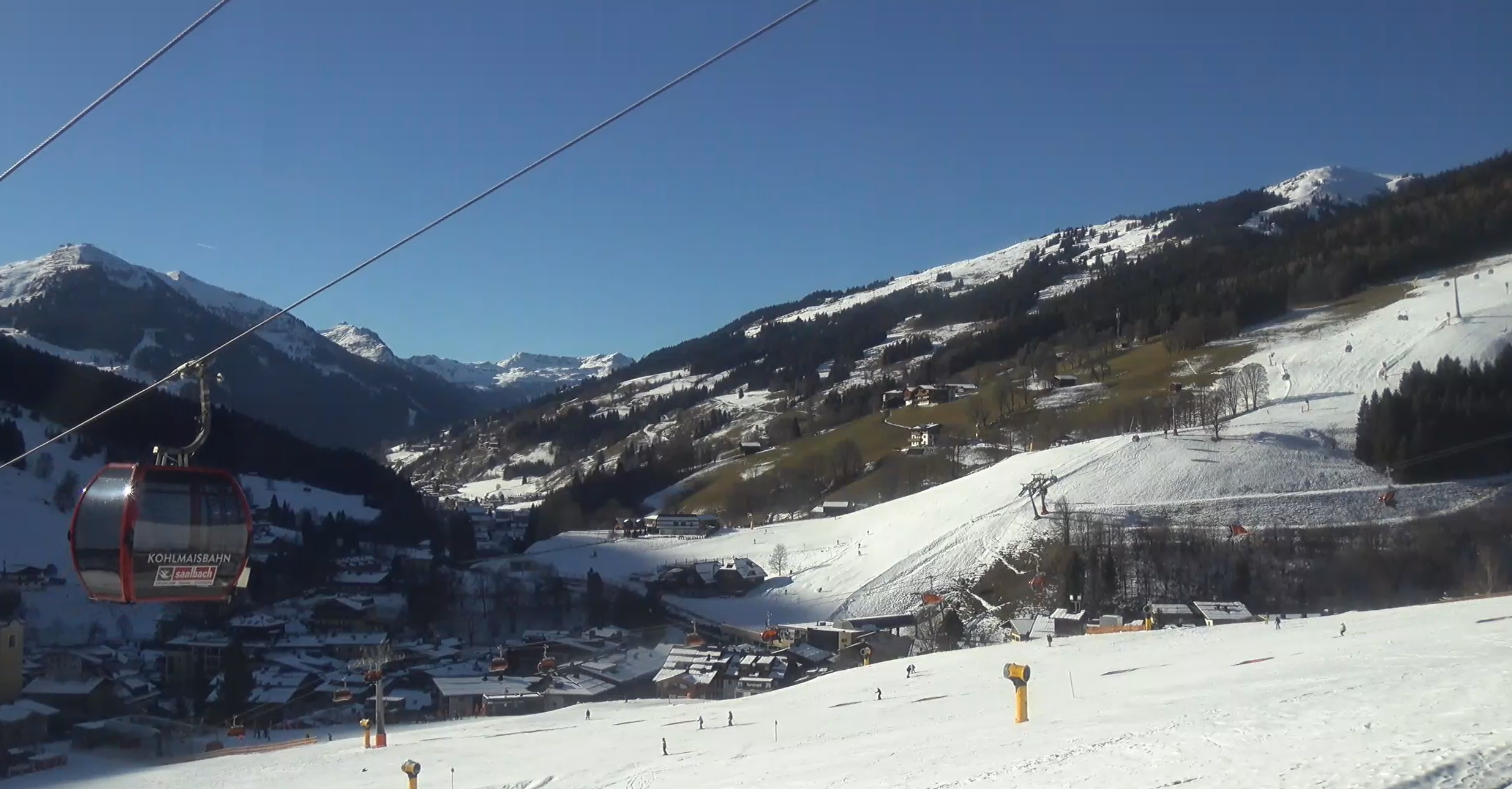 Het dorp Saalbach (1040 meter) ligt zondagmiddag in de schaduw. Op de pistes ligt nog voldoende sneeuw, al wordt het gras op de zuidelijke hellingen alweer zichtbaar. Bron: Feratel