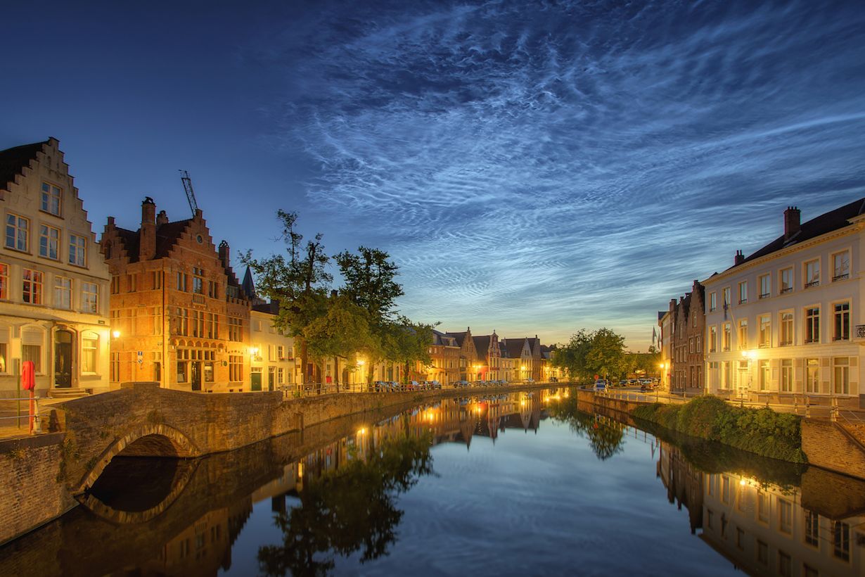 Lichtende nachtwolken vlak na zonsondergang in Brugge. Foto: Adobe Stock / Ivan Kurmyshov