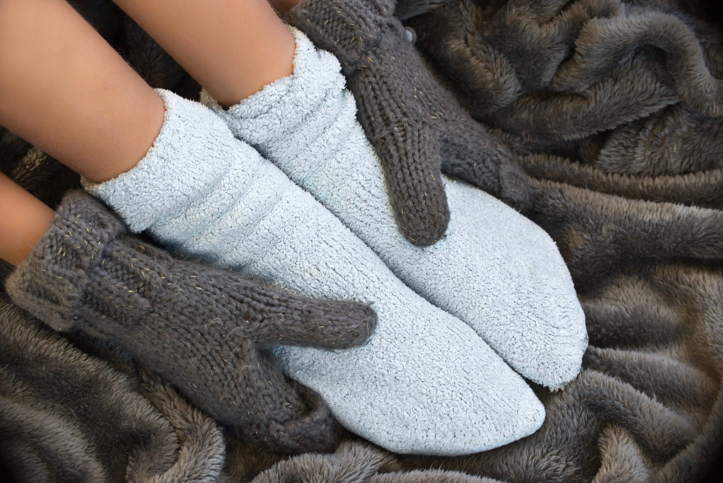 Gebruik warme sokken en handschoenen om je handen en voeten te beschermen tegen de kou. Foto: Adobe Stock / Delphotostock.