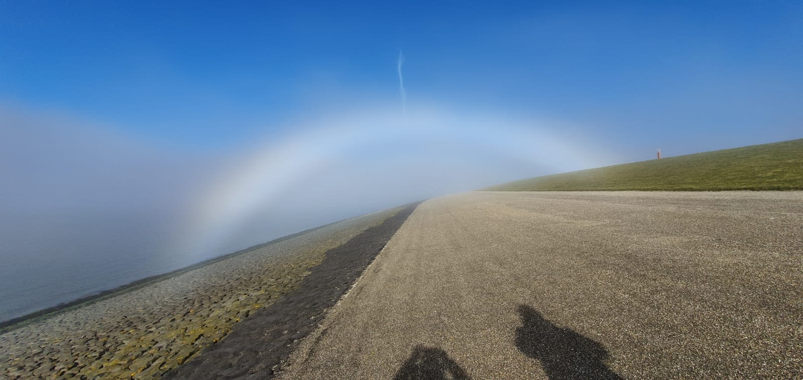 Mistboog op de Waddendijk in Harlingen. Aan de rand is wat kleur zichtbaar. Foto: Wladimir de Gier