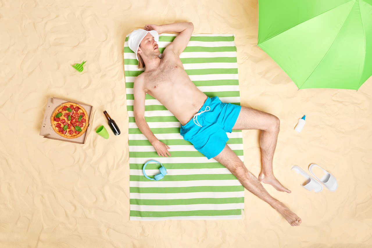 Een dutje doen in de zon op het strand kan heerlijk zijn. Foto: Adobe Stock / Wayhome Studio
