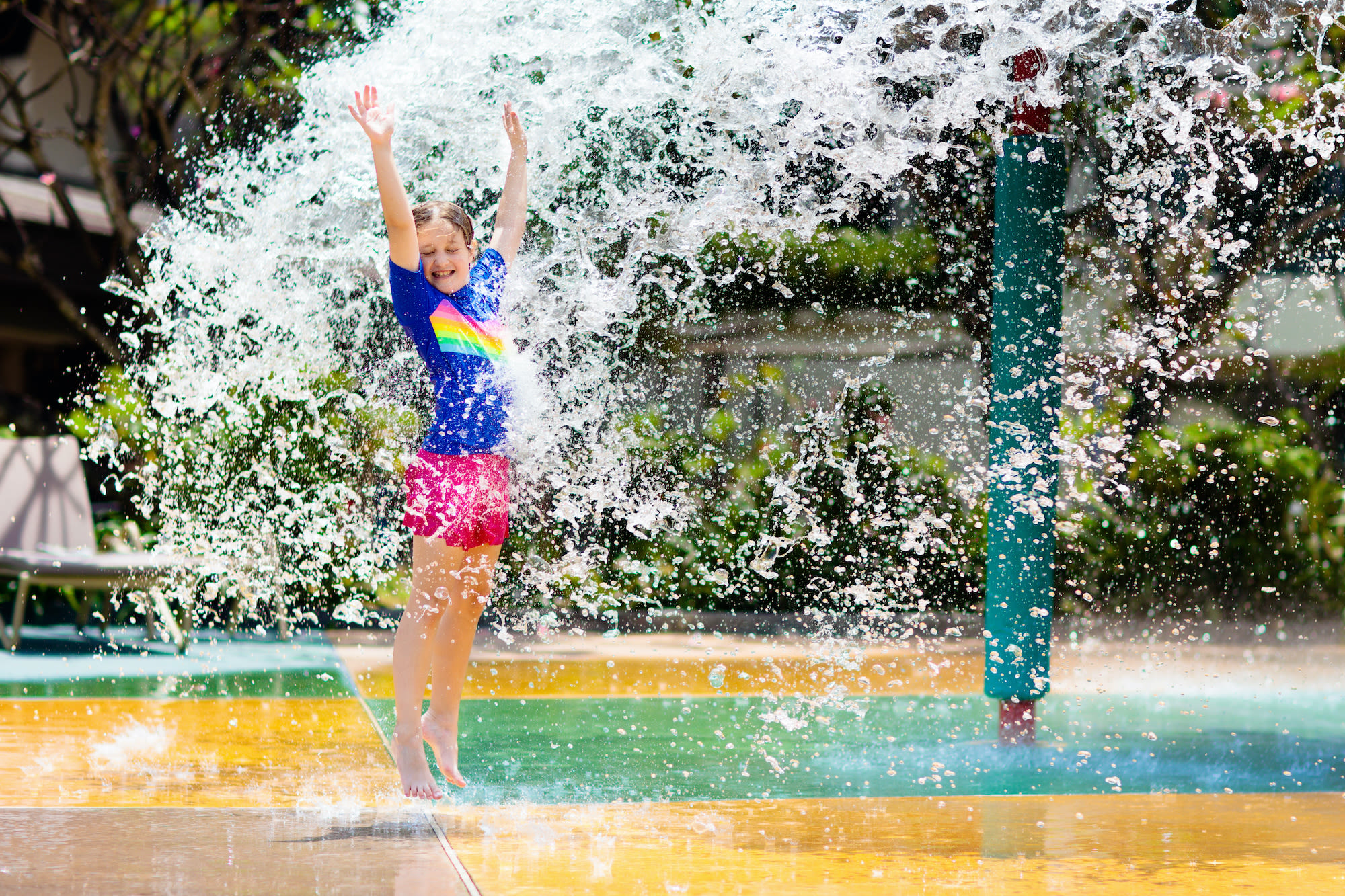 Kind speelt met water in een openbaar zwembad. Foto: AdobeStock / famveldman.