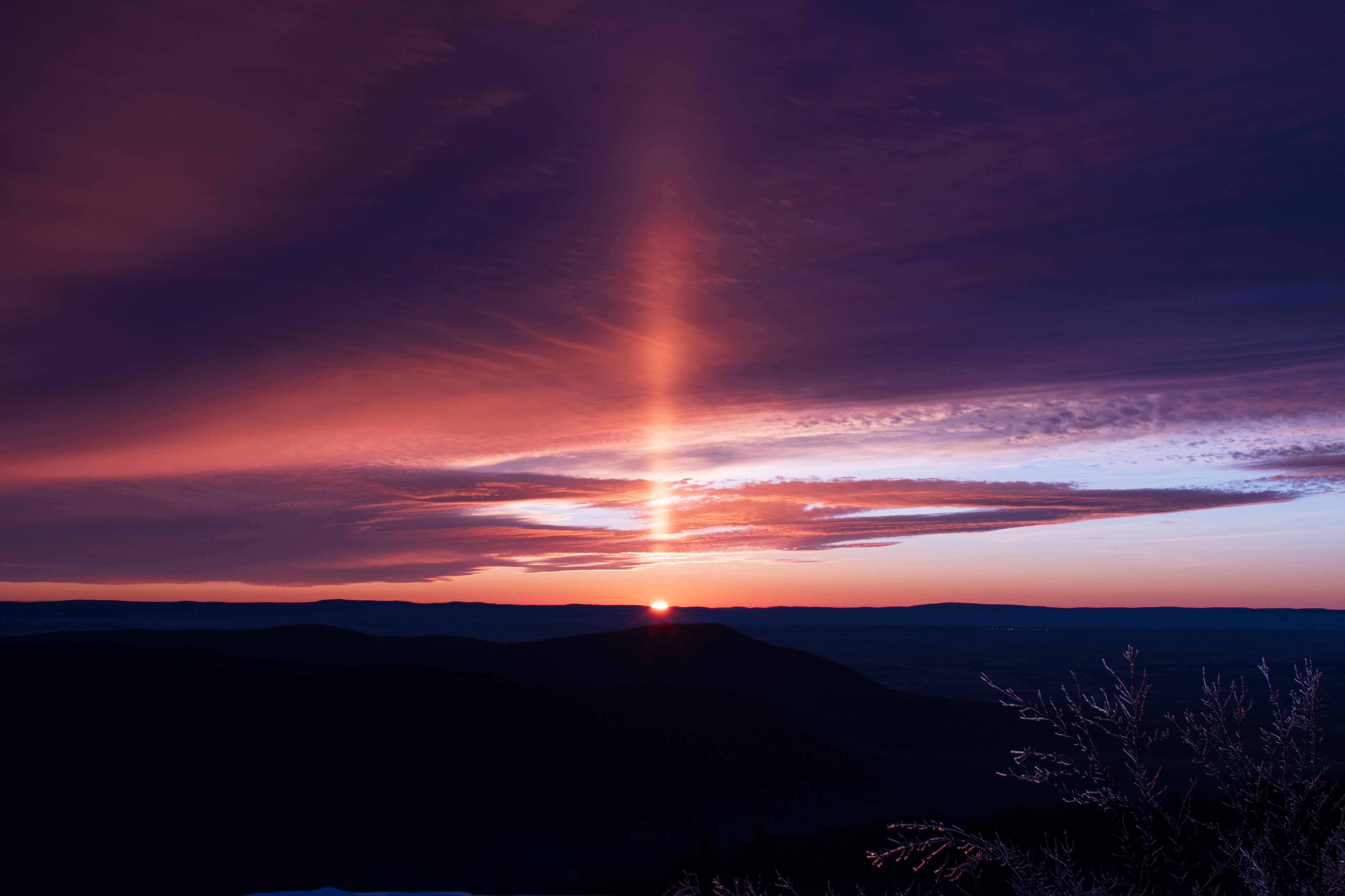 Lichtpilaar op het moment dat de zon net onder de horizon staat. Foto: Adobe Stock / Igor Bastrakov
