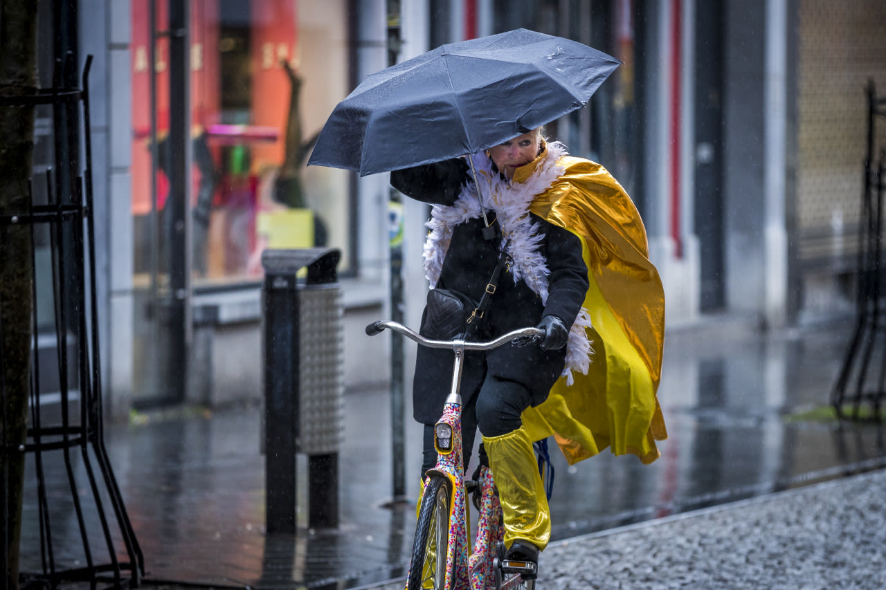 ANP-feestvierder-carnaval-op-fiets-door-regen-en-wind-in-Maastricht
