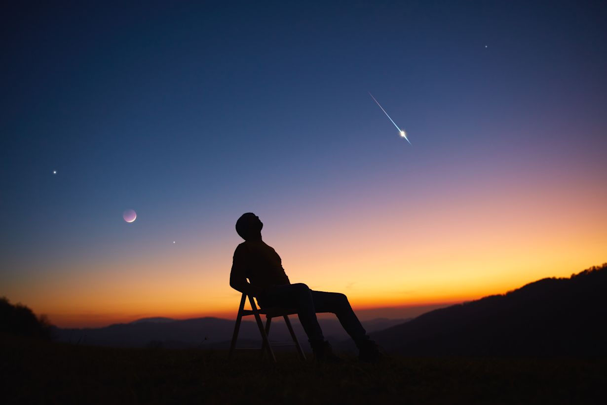 Zittend kijken naar de sterrenhemel. Foto: Adobe Stock / astrosystem