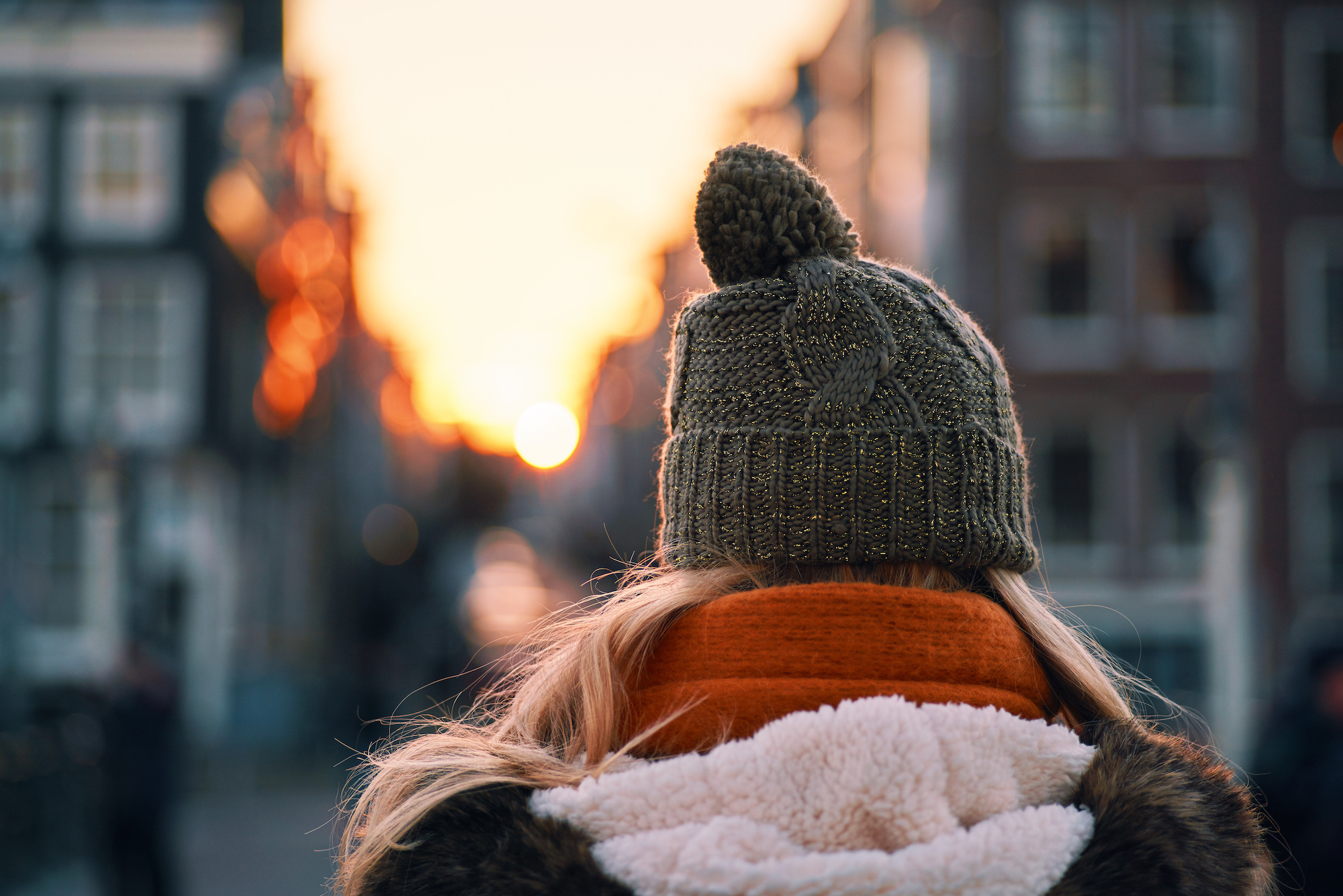 Koud weer in december Amsterdam muts op ondergaande zon.