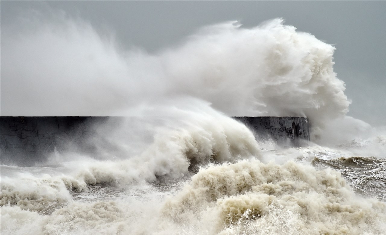 Golven slaan over Newhaven Lighthouse aan de zuidkust van Engeland. Foto: AFP / ANP / GLYN KIRK.
