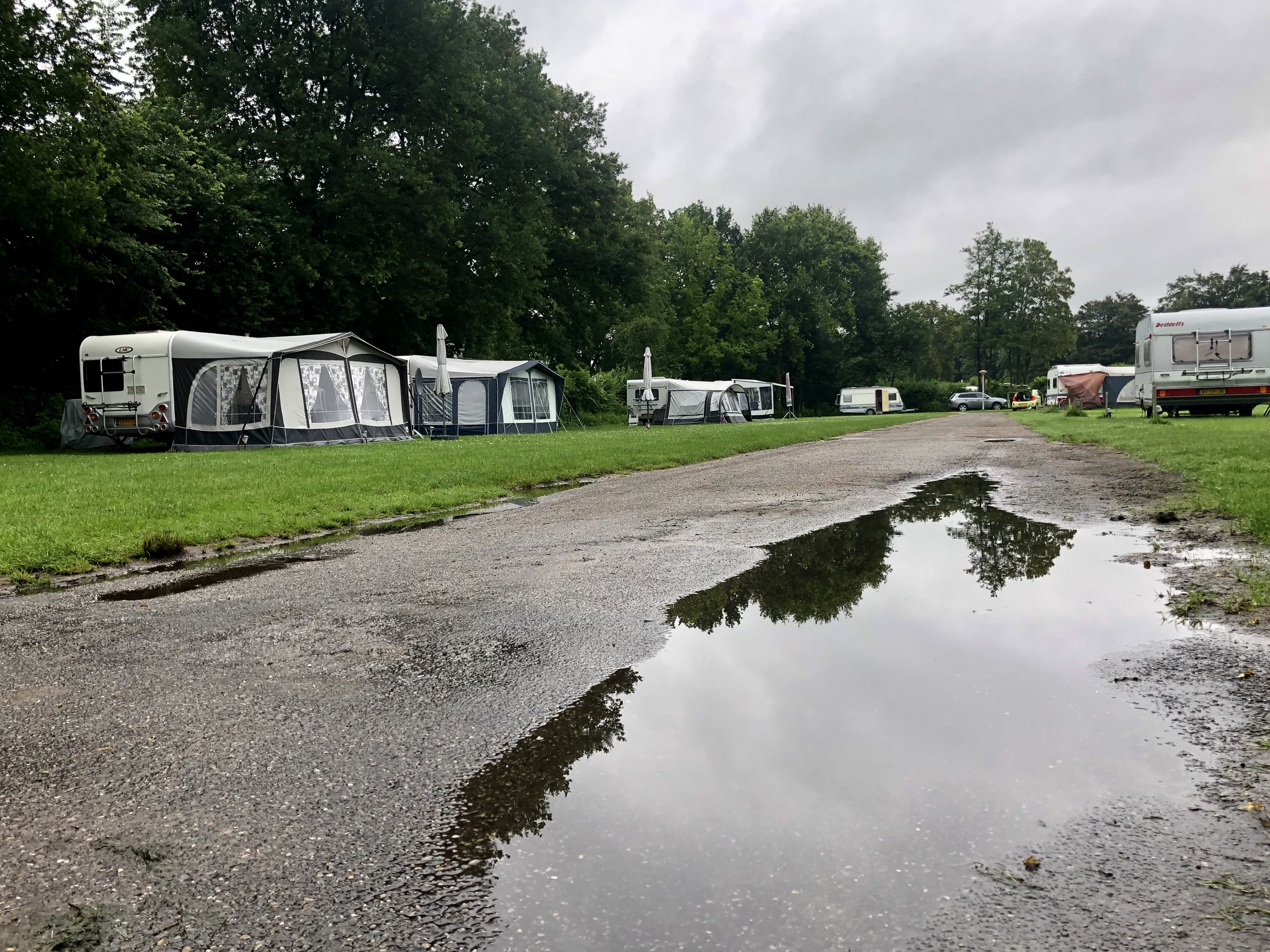 Plassen water door regen op verlaten camping in de zomer