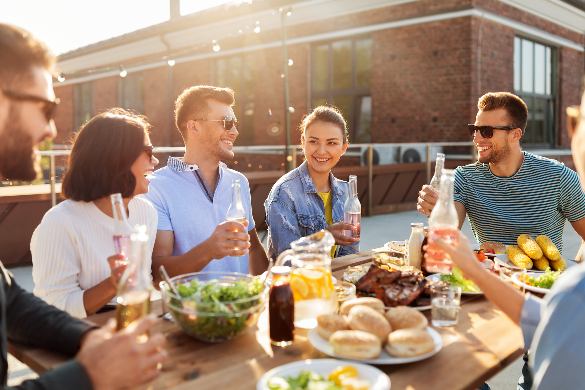 Buiten eten op een zonnige en warme avond. Foto: Adobe Stock / Syda Productions