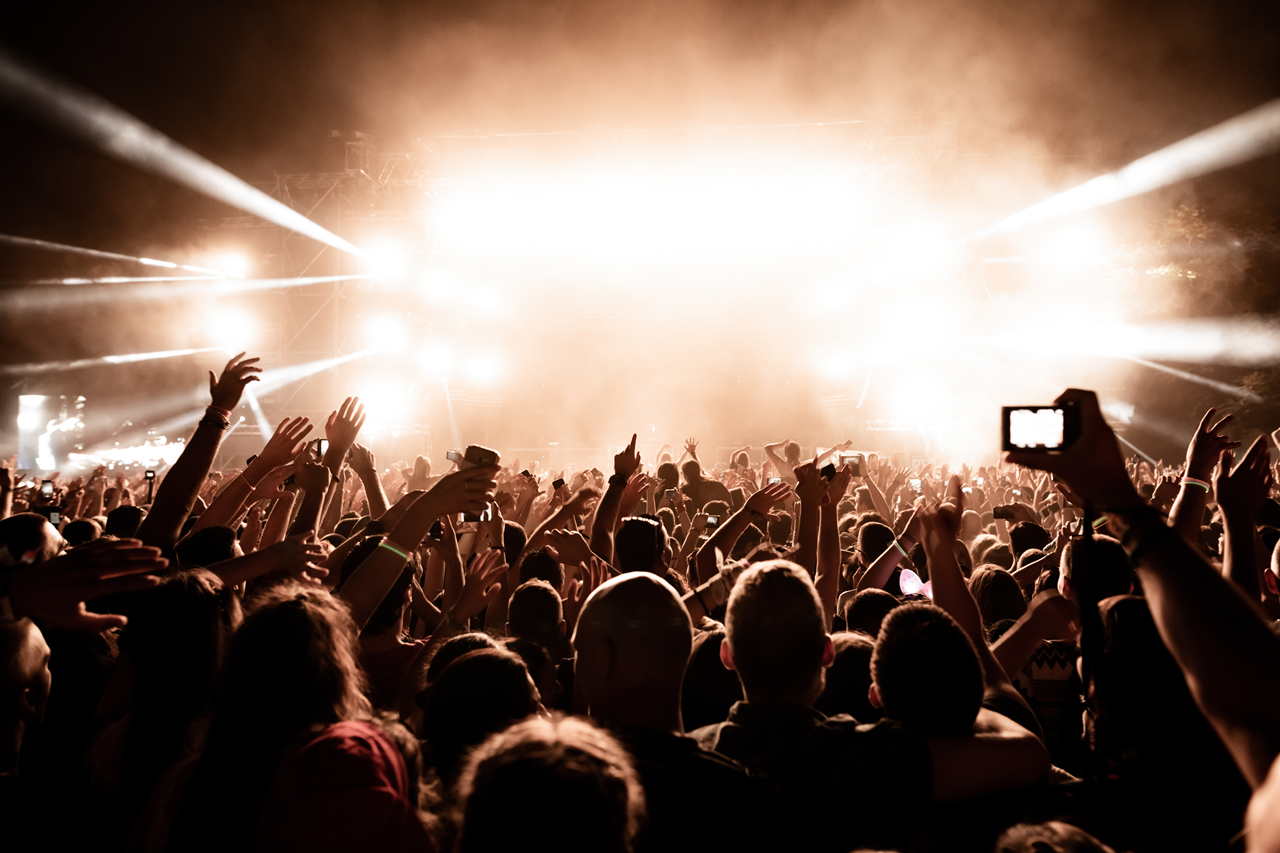 Een muziekfestival in de avond. Foto: AdobeStock / Drazen