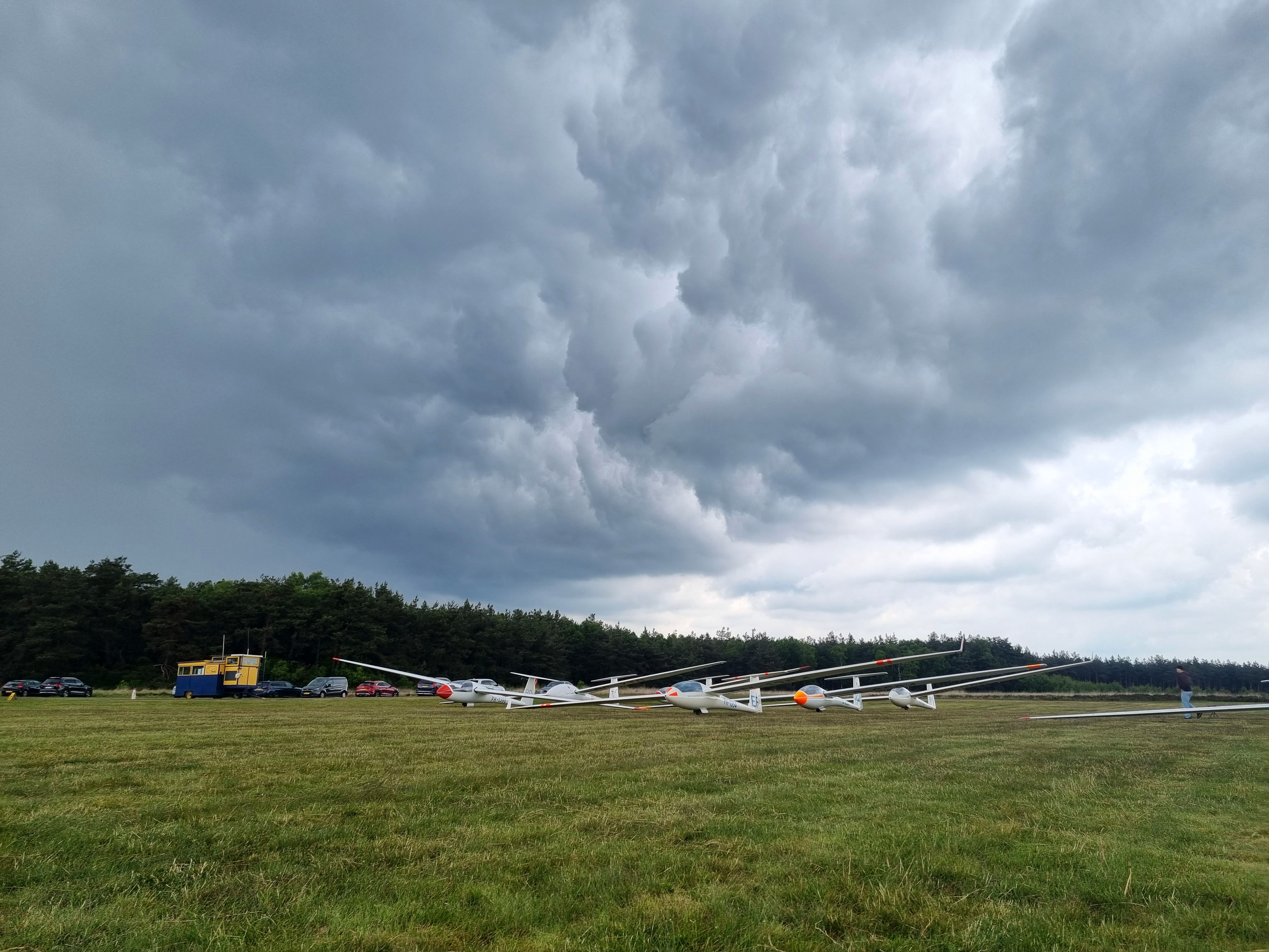 Zweefvliegtuigen aan de grond door een onweersbui tijdens het NK Zweefvliegen op Terlet. Foto: Julian.