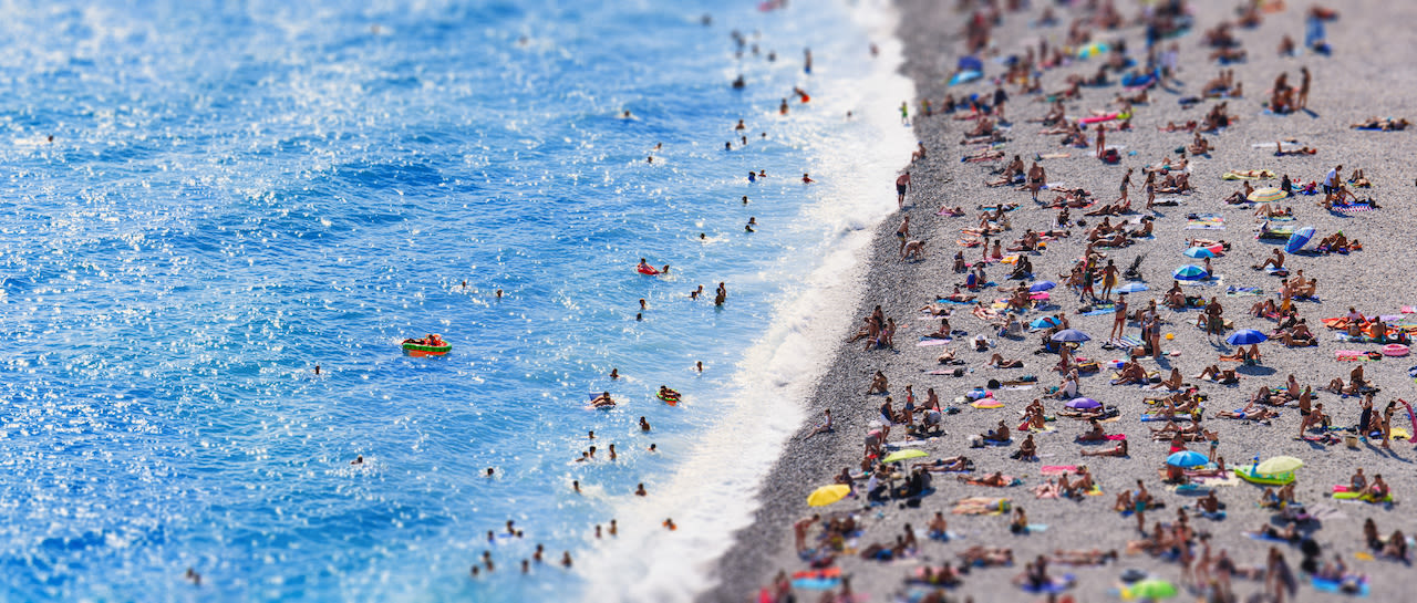 Vol strand in de zomer in Zuid-Europa. Foto: Adobe Stock / Igor.