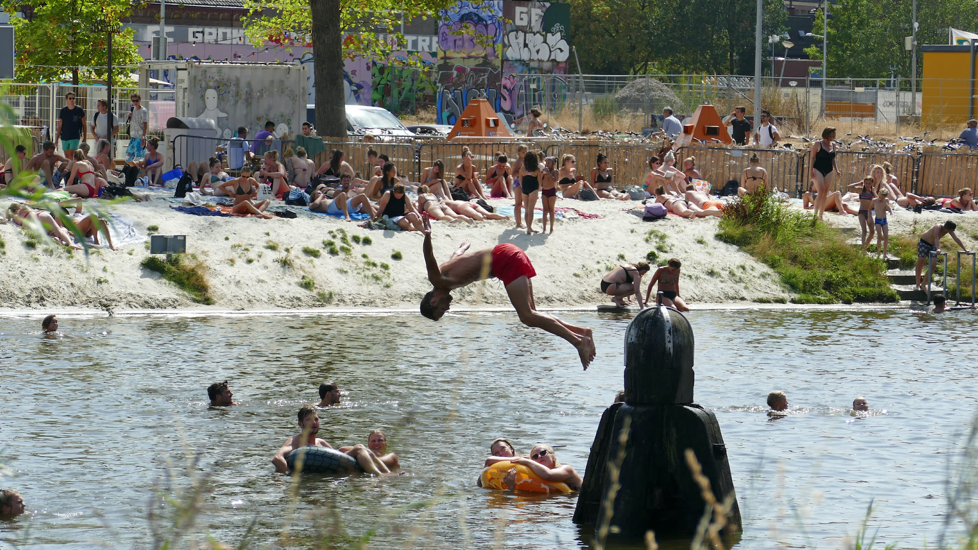 Op een hete zomerdag neemt een jongen een duik in een waterplas in Groningen. Foto: Gerrit Draaisma. 