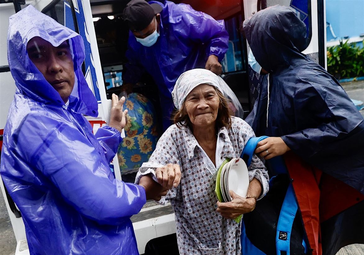 Dorpsbeambten helpen een oudere vrouw (C) tijdens de evacuatie in de stad Ilagan, provincie Isabela, Filippijnen. Foto: FRANCIS R. MALASIG.