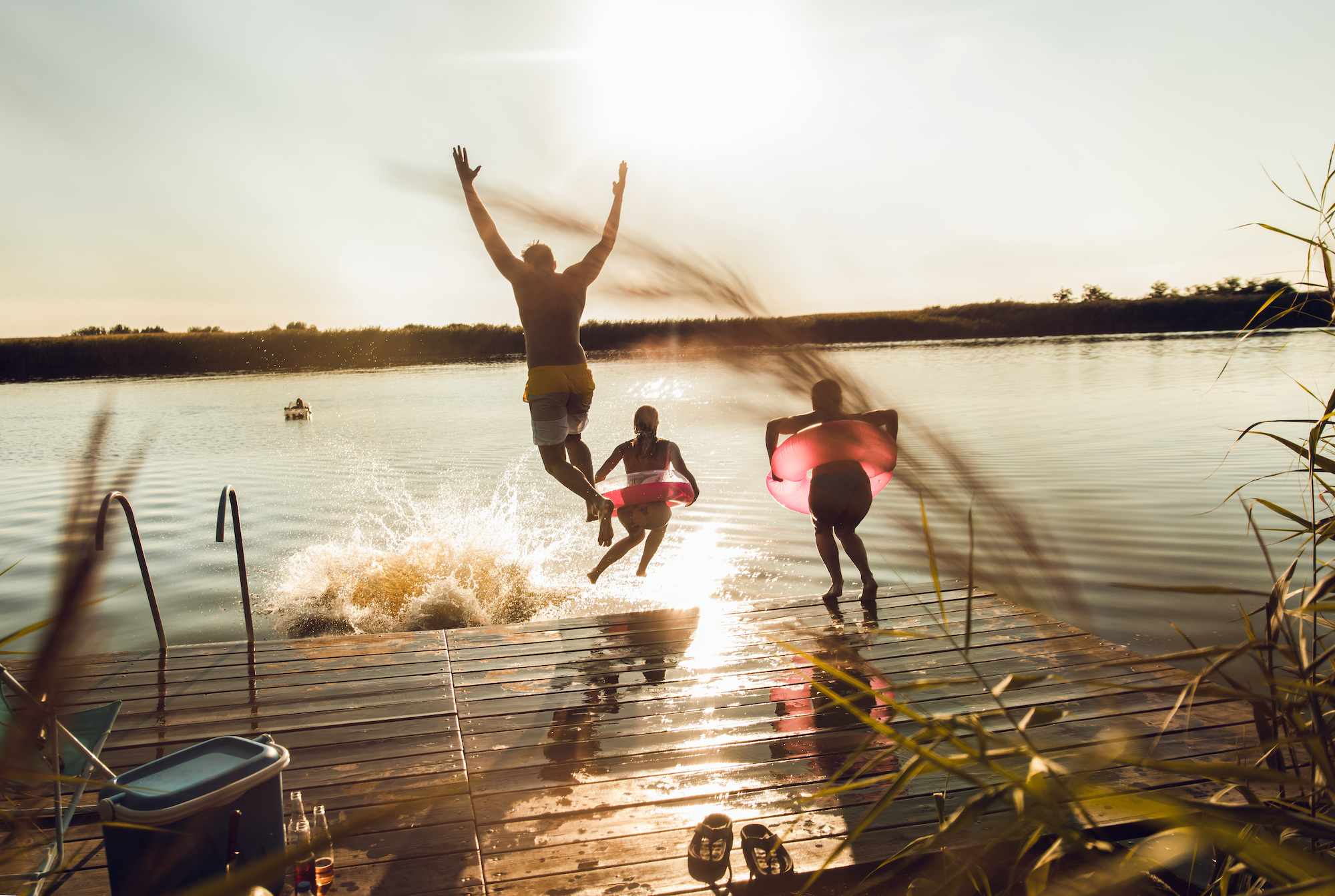 Gezin plonst in het water van een meer tijdens mooi warm weer in de zomer