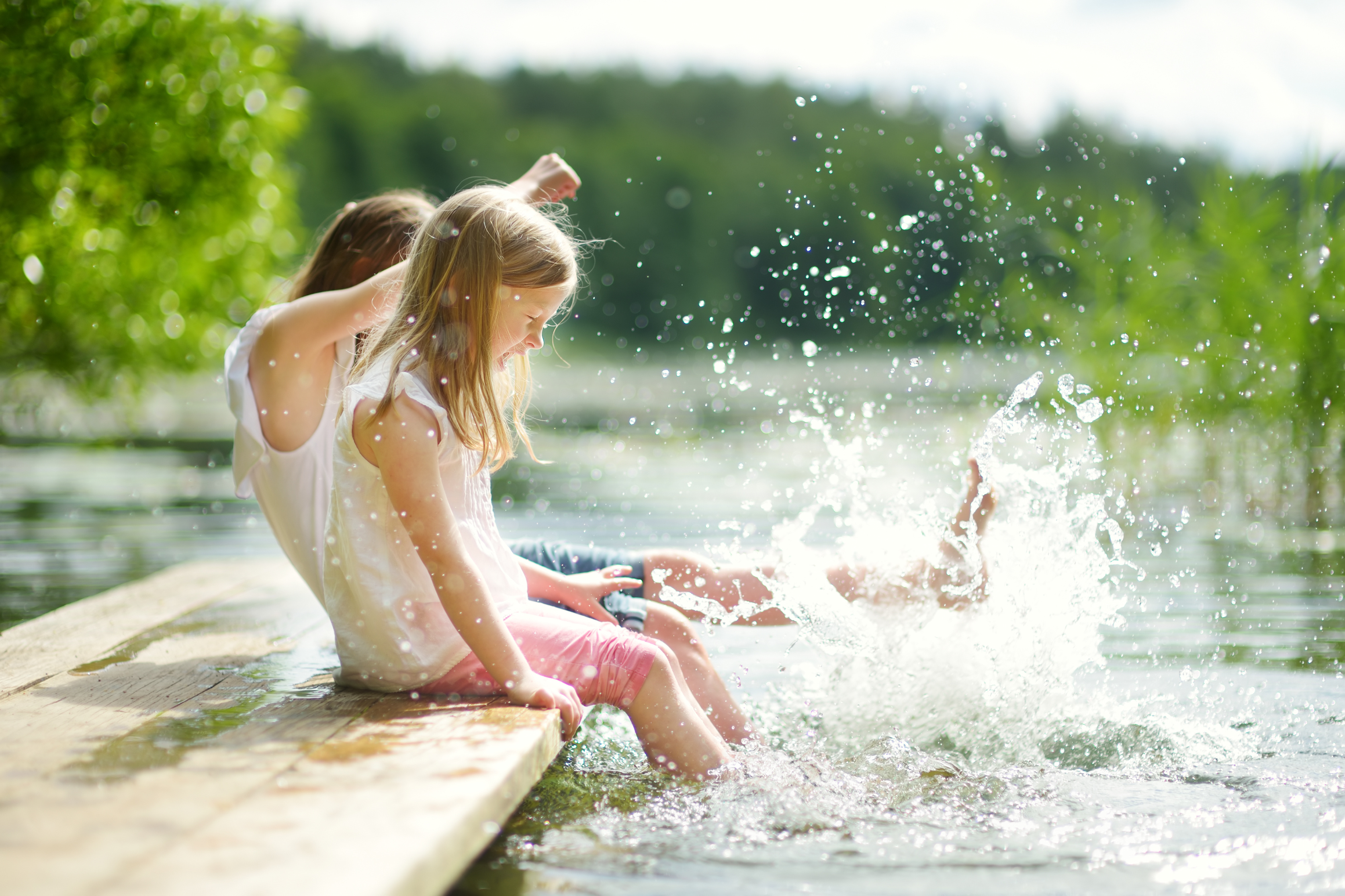 Twee meisjes spelen aan het water op een steiger tijdens mooi weer in de nazomer