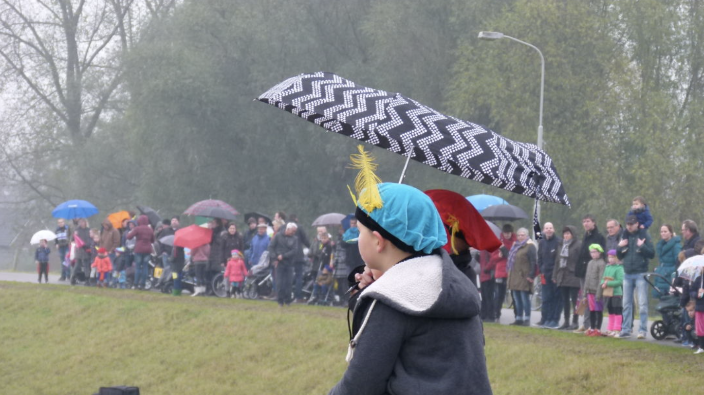 Kindjes wachten in de regen met paraplu op intocht Sinterklaas. Foto: Loes van Eck-Verhoeven