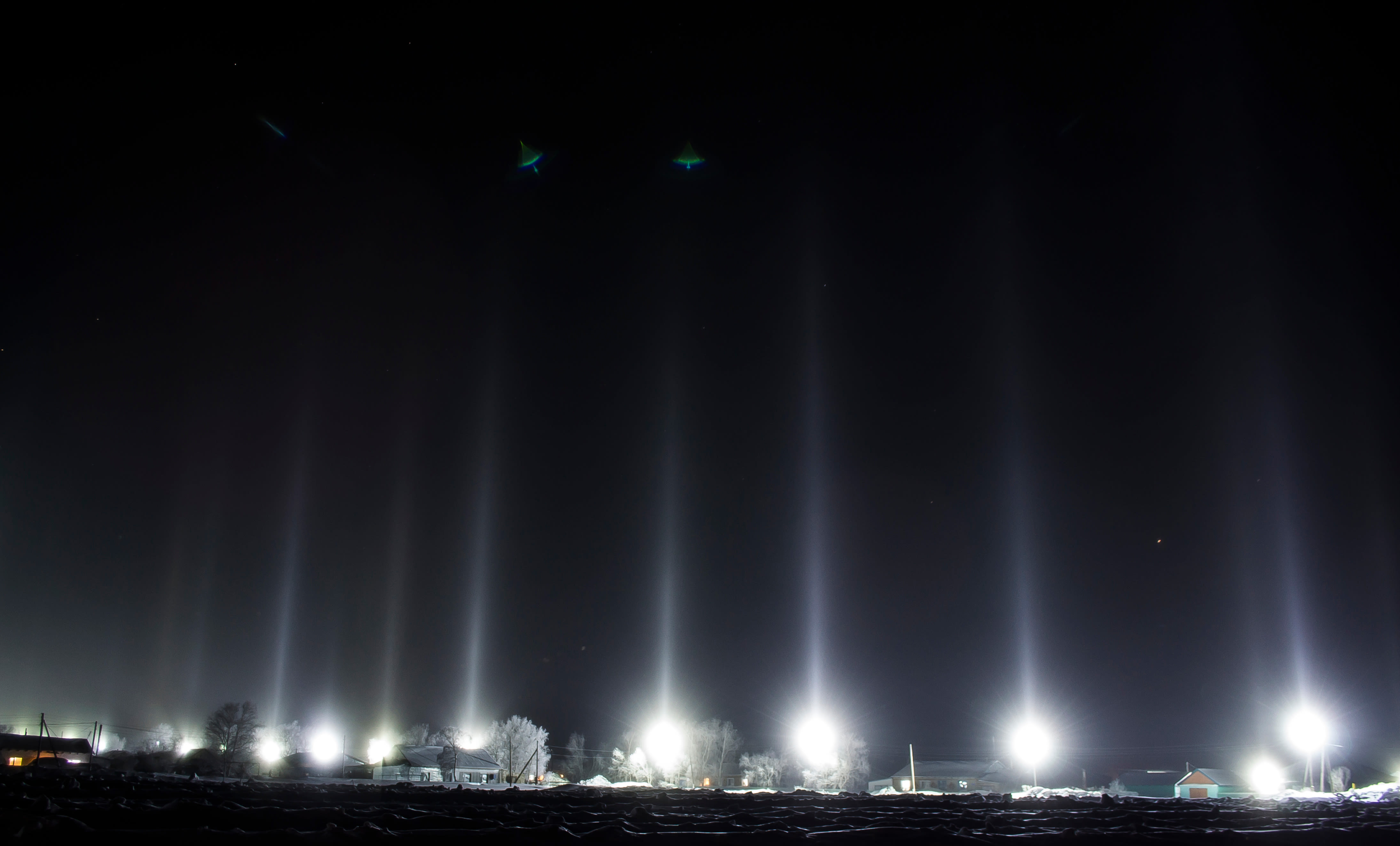 Lichtpilaren boven straatverlichting tijdens strenge vorst. Foto: Adobe Stock / Igor Bastrakov