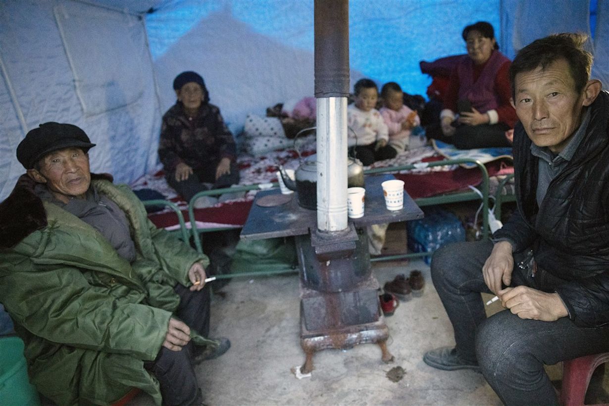 Mensen proberen zich warm te houden in tenten nadat het gebied Gansu getroffen is door een aardbeving. Foto: ANP/EPA/ANDRES MARTINEZ CASARES