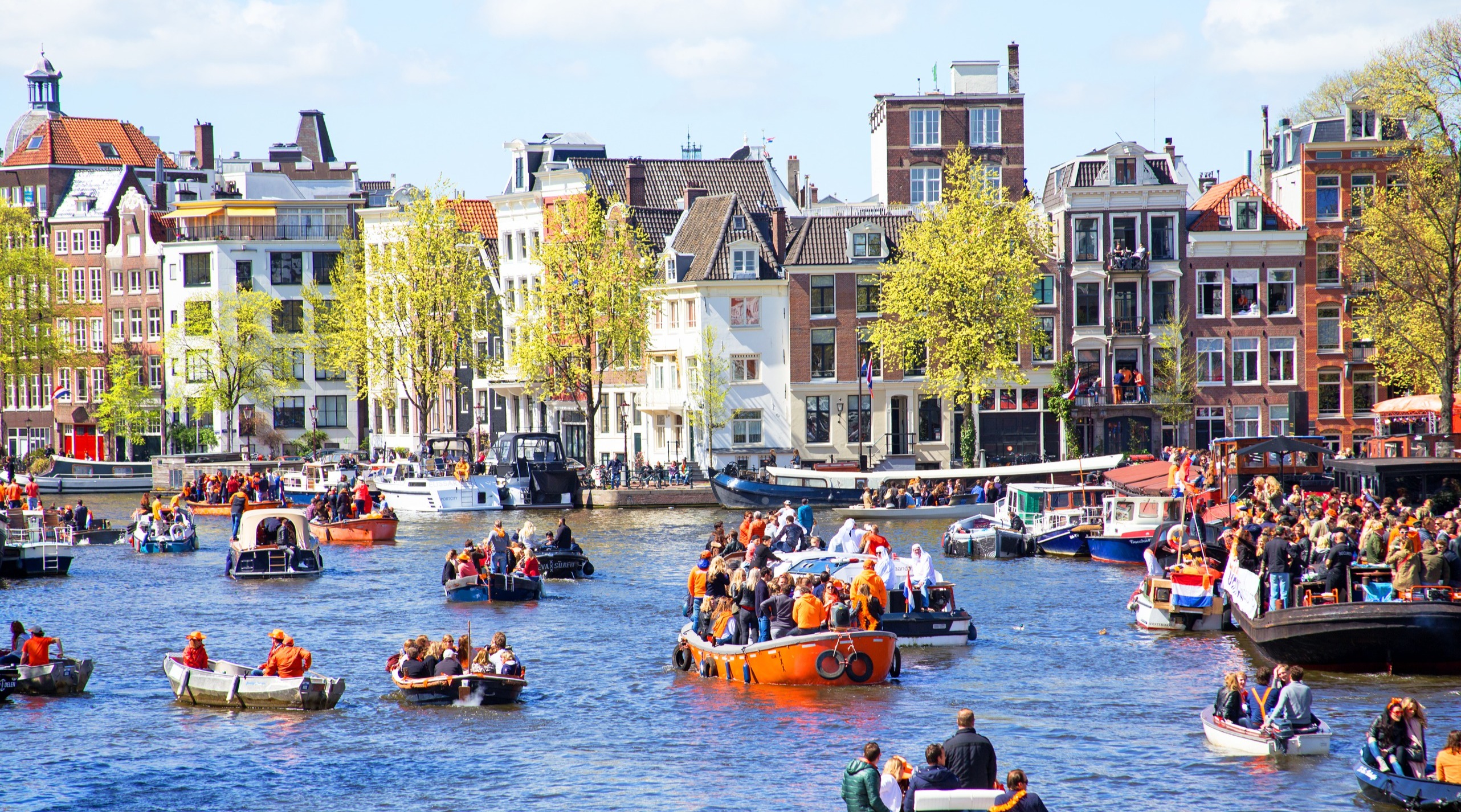Op de Amsterdamse grachten tijdens Koningsdag. Foto: Adobe Stock / Nataraj