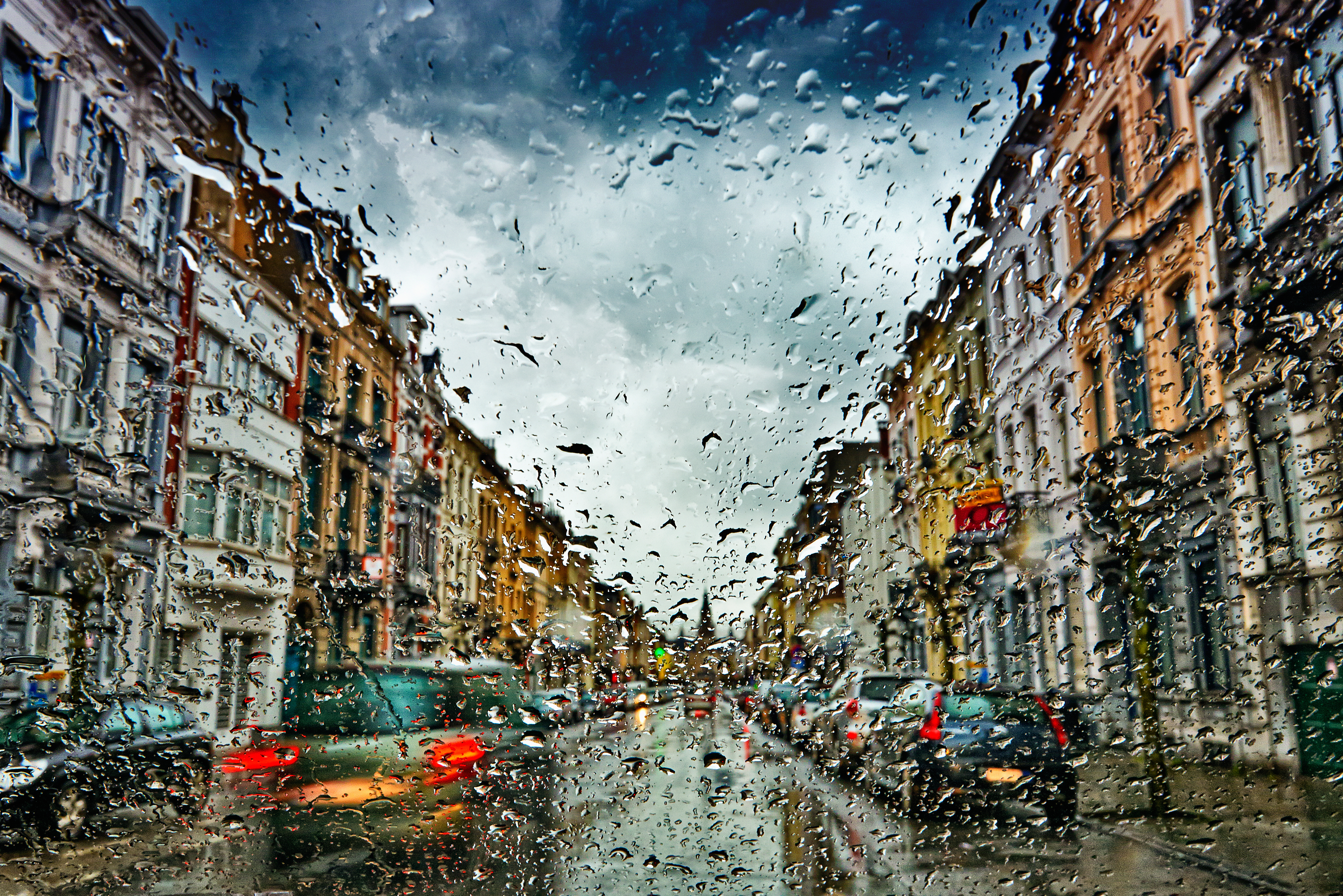 Regen op autoraam in de Belgische straten. Foto: Adobe Stock / pbombaert
