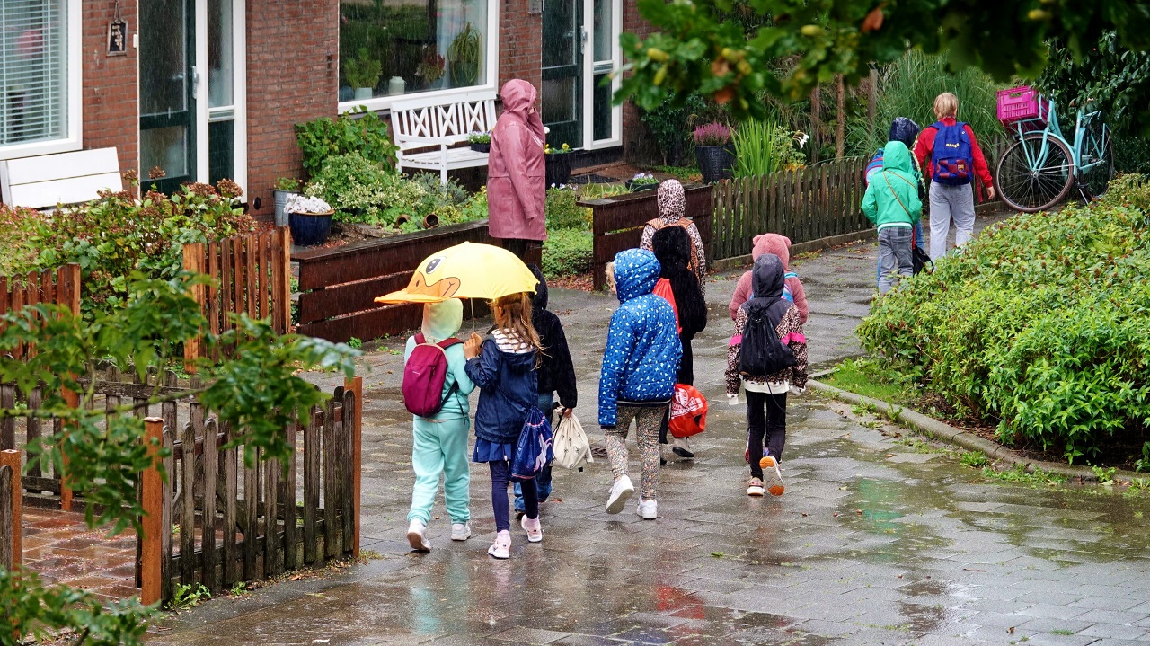 Kinderen in de regen op een kletsnatte dag. Foto: Ton Wesselius