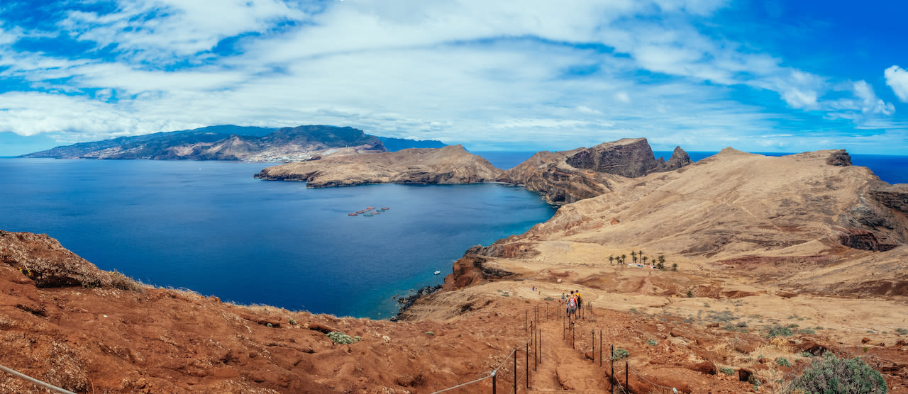 Het schiereiland Ponta de São Lourenço wordt gekenmerkt door de rode rotsen. In de verte zie je dat het centrale deel van Madeira veel groener is. Beeld: Adobe Stock / Arnaud.
