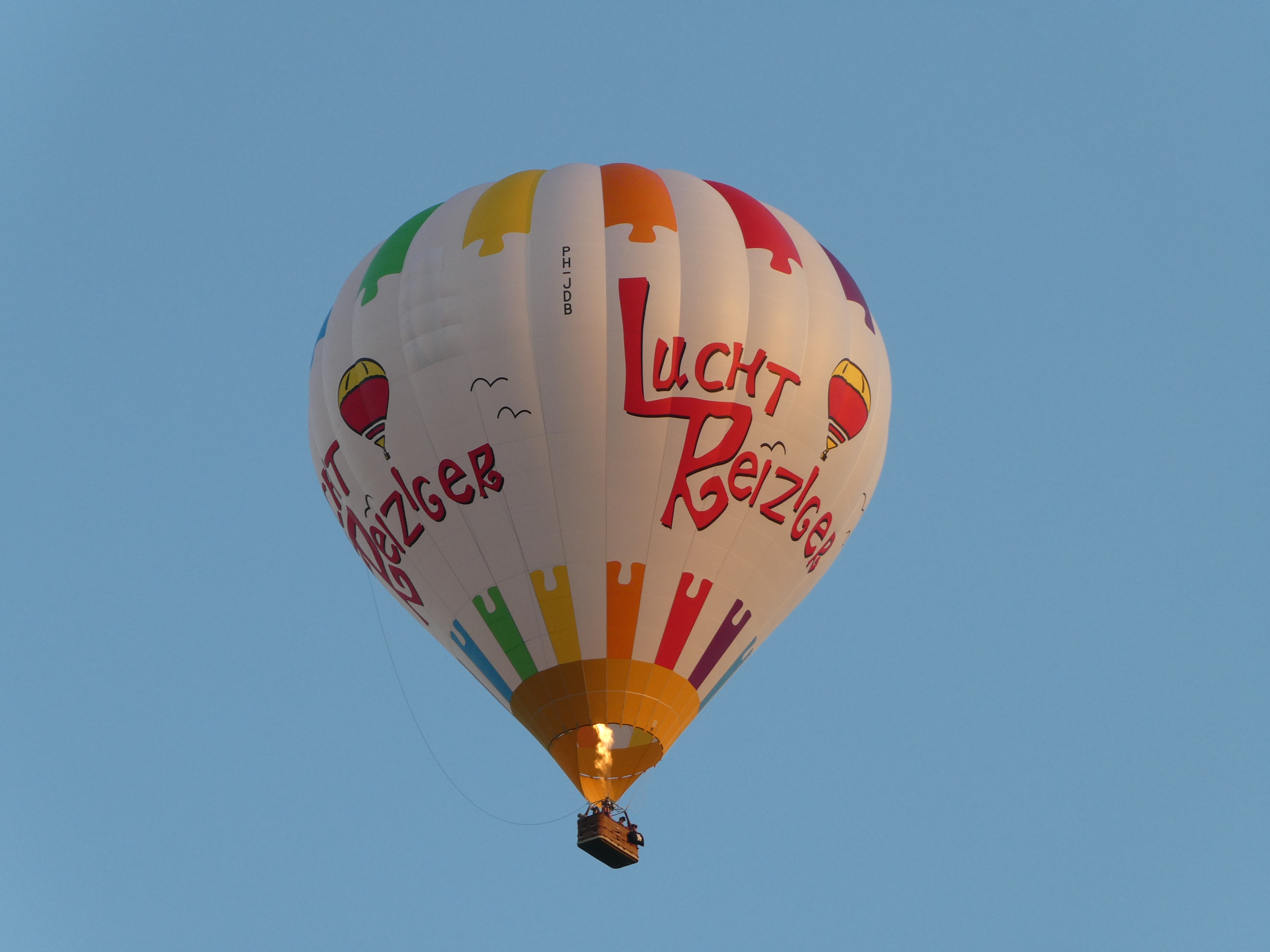 Een ballonvaarder laat de ballon stijgen door warmte toe te voegen aan de lucht in de ballon. Foto: Ria de Wit.