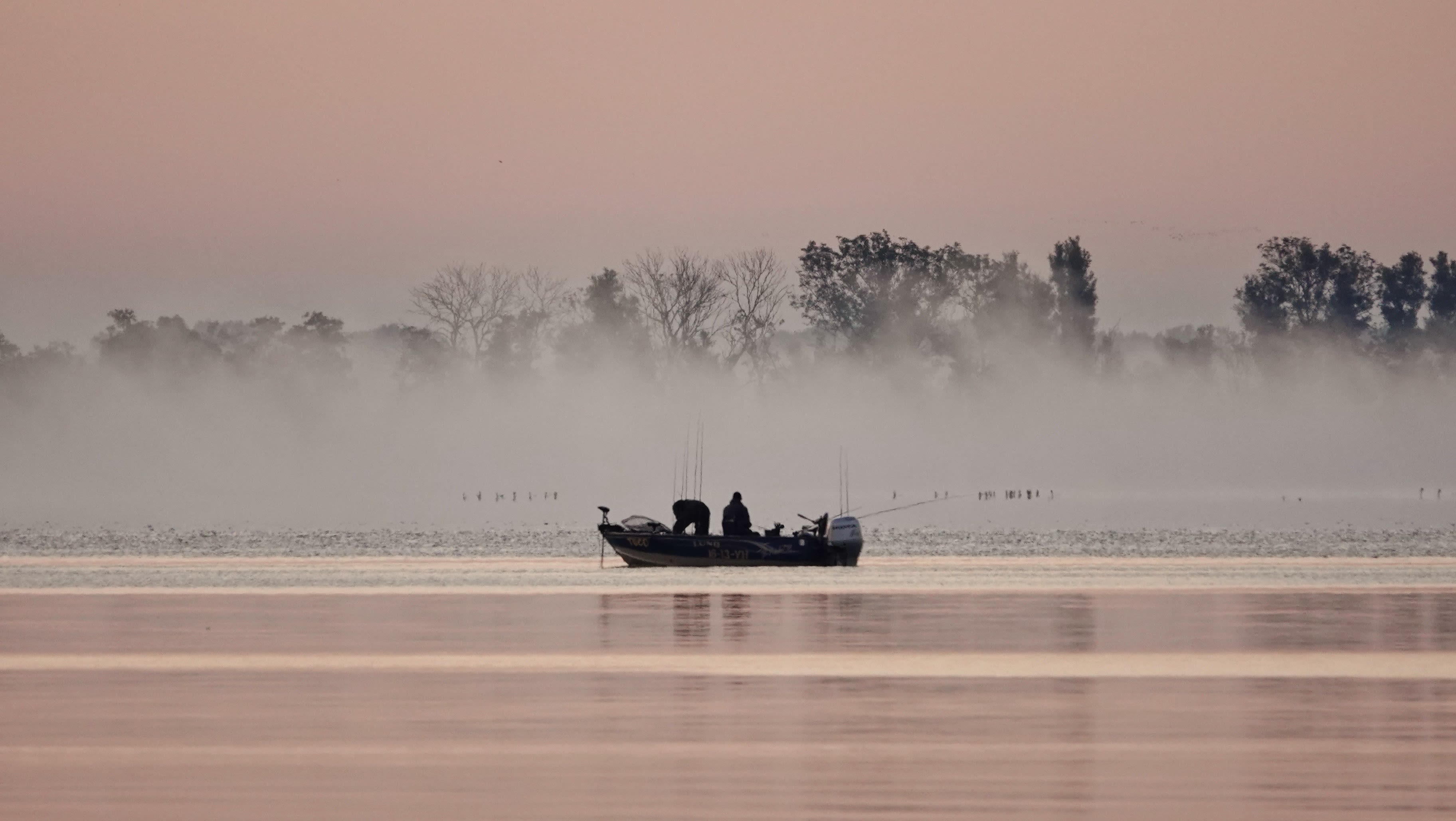 Mist boven meer met bootje op voorgrond. Foto: Ton Wesselius.